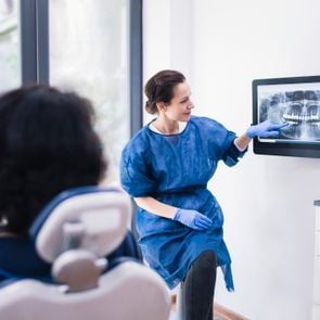 Dentist Explaining Tooth X-Rays To A Patient.