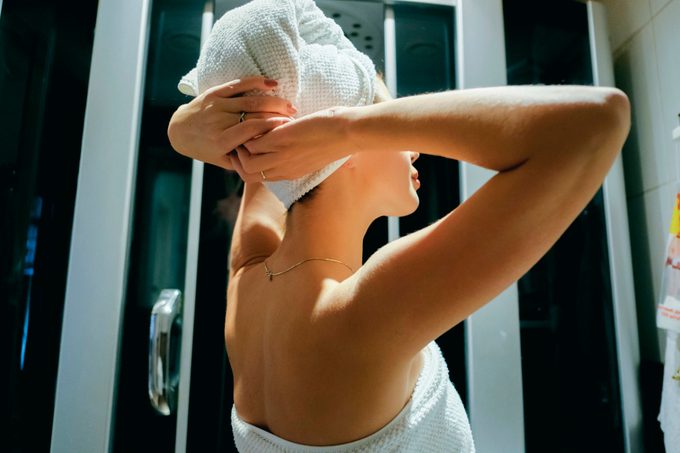 Mulher caucasiana, secando o cabelo com toalha