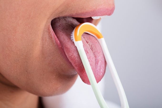 Woman Cleaning Tongue