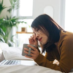 Young woman feeling tired when using laptop working from home