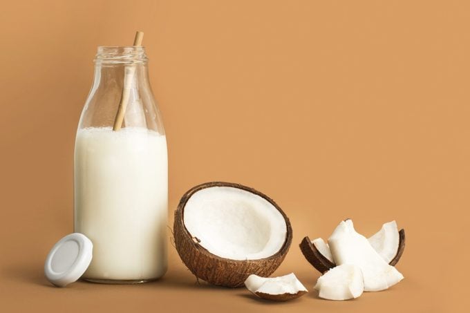 A bottle of coconut milk and pieces of coconut
