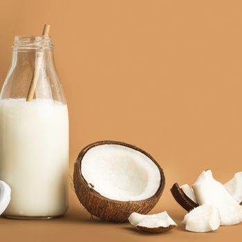 A bottle of coconut milk and pieces of coconut
