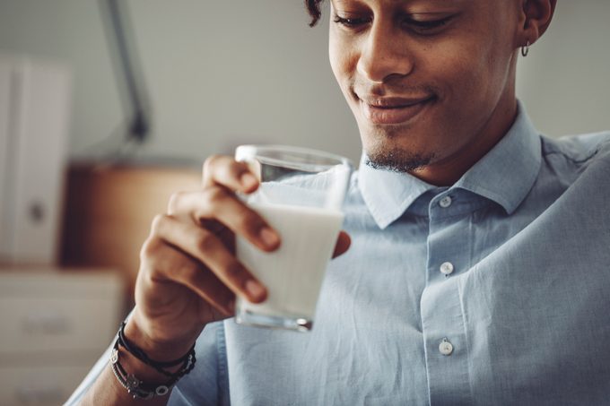 Young man at home drinking a glass of milk