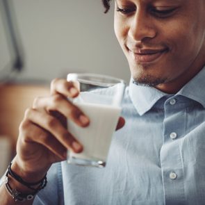 Young man at home drinking a glass of milk