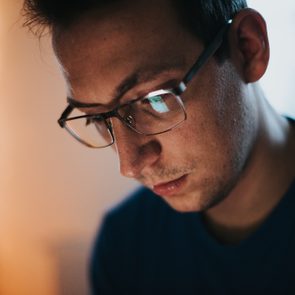 Close-up of a part of a male human face with glasses in neon light stock photo