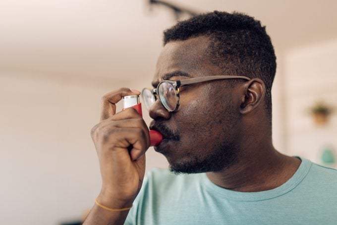 Headshot of a man using asthma inhaler