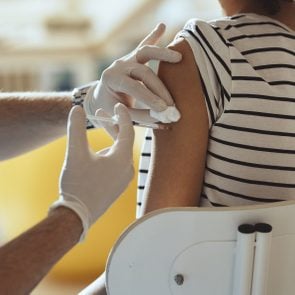 cropped shot of young woman getting injection in arm