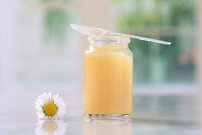 Royal jelly in a glass jar on a counter
