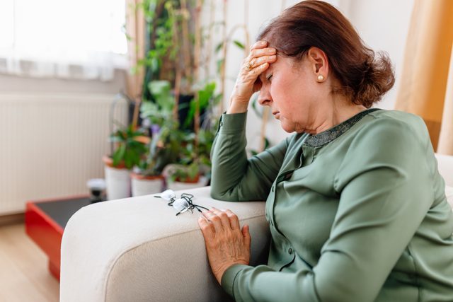 A Distraught Senior WoMan Suffering From a Migraine