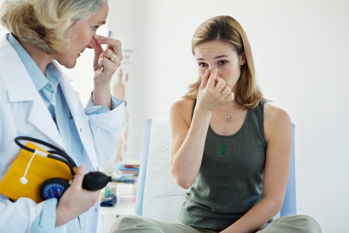 woman with sinus infection talking to ENT doctor