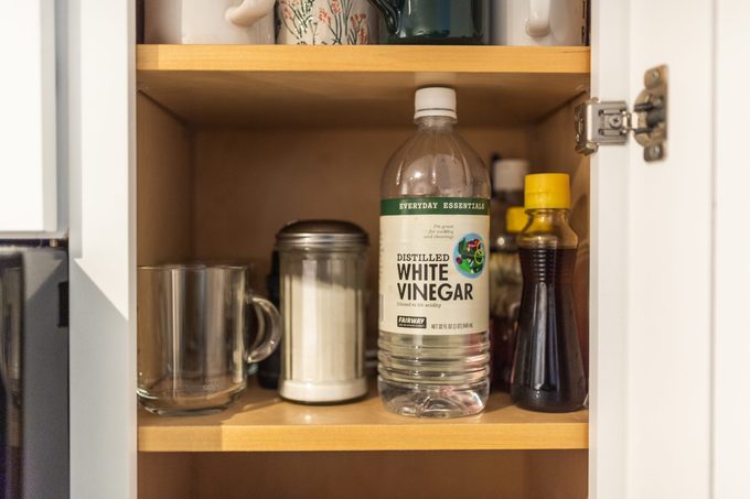 White Vinegar bottle on shelf in kitchen cabinet