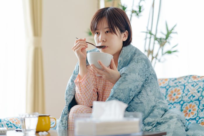 Sick woman having soup to recover