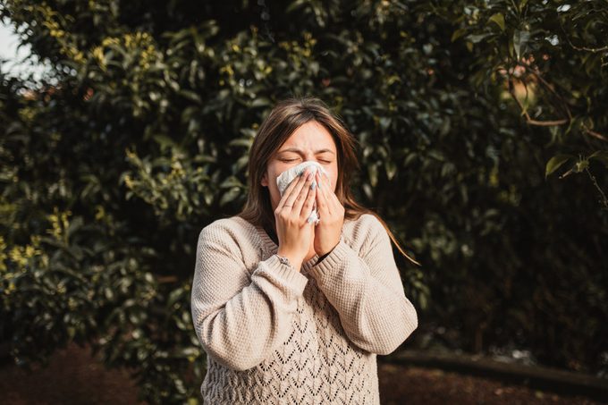woMan sneezing from the cover disease after getting vaccinated