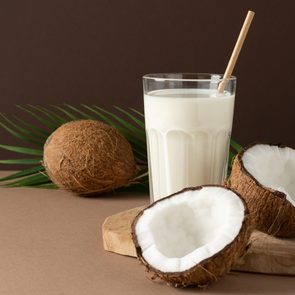 glass of coconut milk on brown background in studio setting
