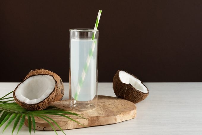 glass of coconut water on brown studio background