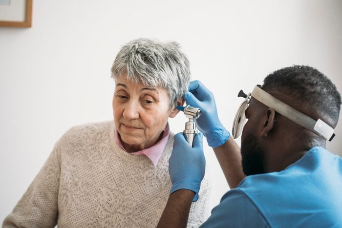 An older woman having her ears checked by the ear doctor