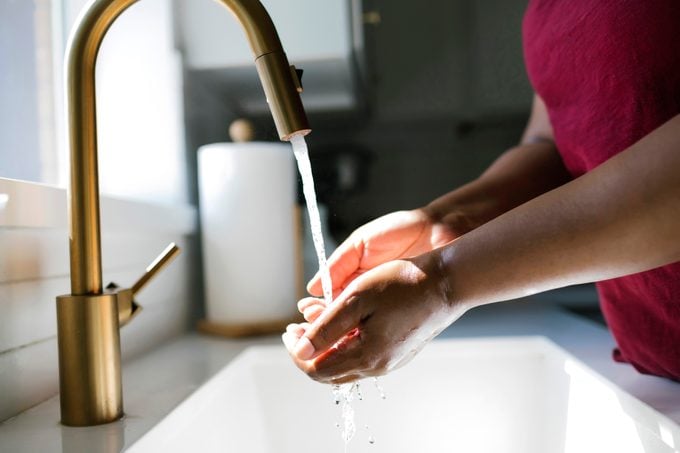 Close-up of woman washing hands in kitchen sink