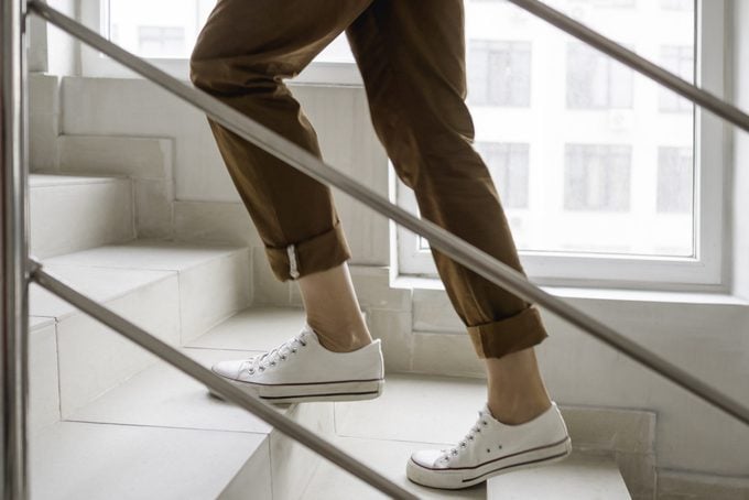lower half of woman walking up stairs