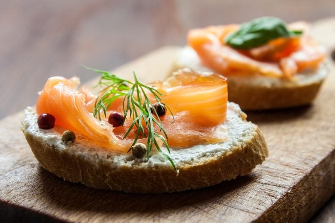 Smoked salmon canapes on a brown wooden plate