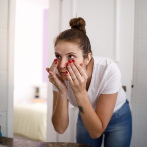Young woman doing skin care at bathroom