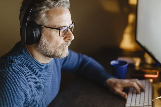 mature man working on computer while wearing blue light blocking glasses