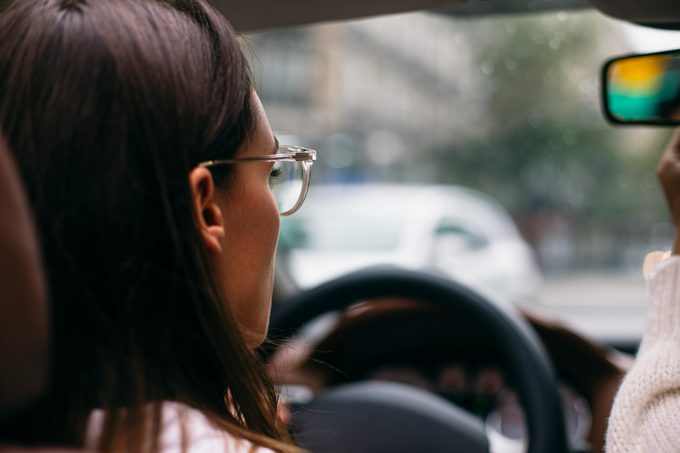 close up of woman wearing glasses while driving