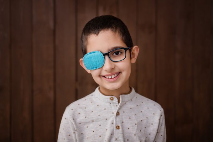 Portrait of boy in glasses with patch for lazy eye, amblyopia, strabismus treatment