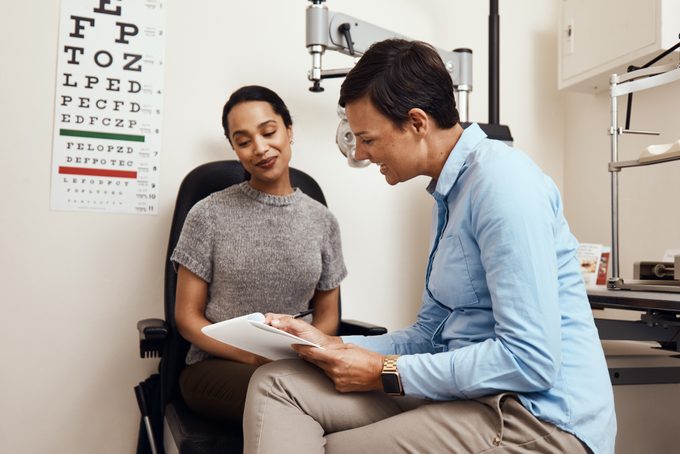 eye doctor and patient talking about health concerns