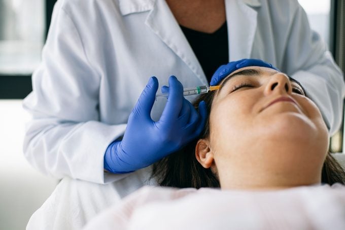 Woman receiving botox in face for migraine treatment