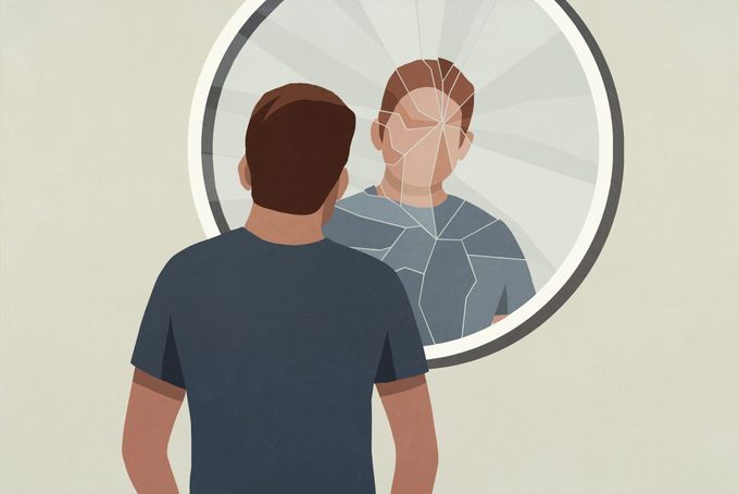 Illustration of young man looking into cracked mirror