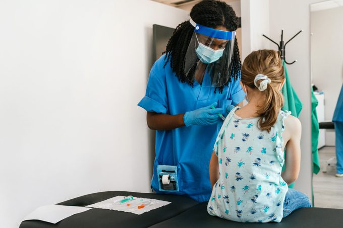 Rear View Of A Young Girl Receiving Covid-19 Vaccine