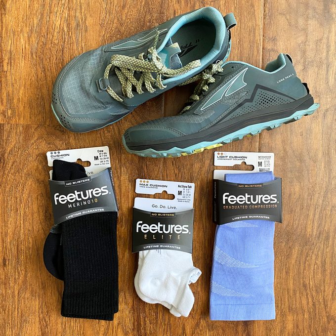 Feetures socks products and sneakers on wood floor