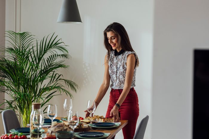 Young Woman Setting Up Dinner Table for dinner party