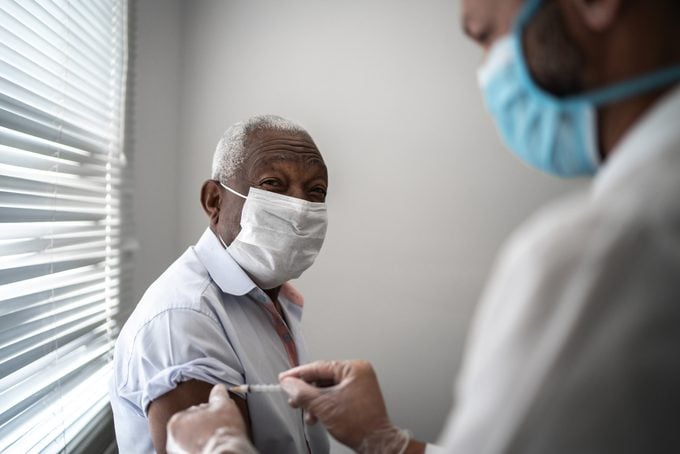 mature man receiving a vaccine shot from doctor