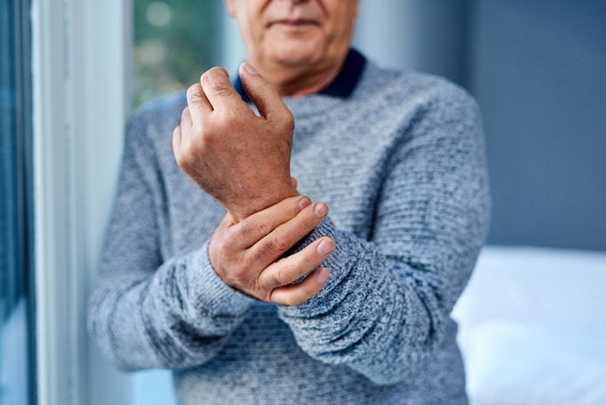 anonymous man holding his wrist joint in pain