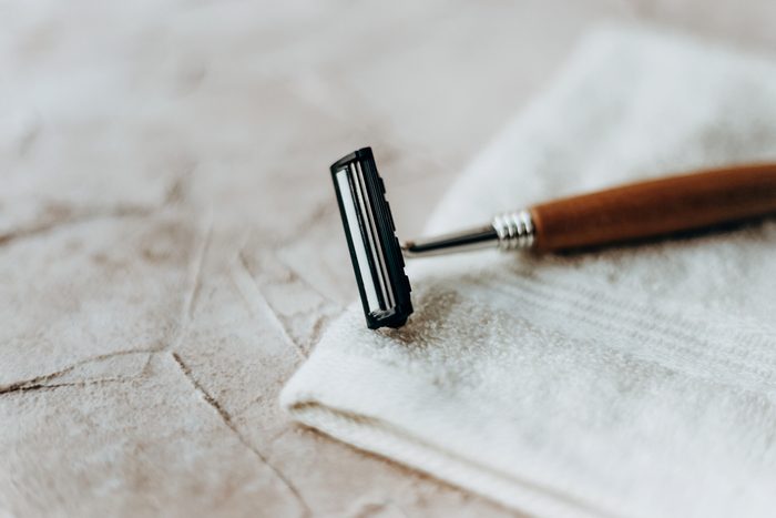Eco razor with a wooden handle lies on a white towel