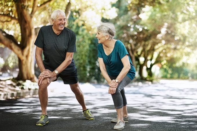 Una foto de una pareja de ancianos calentándose afuera antes de correr