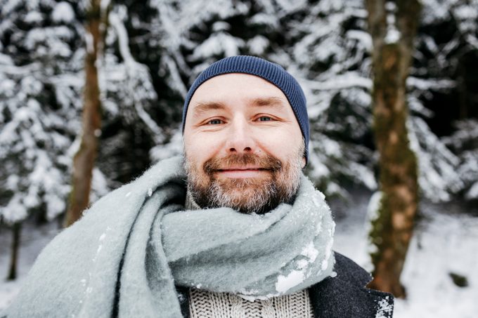 man with beard standing in the snow
