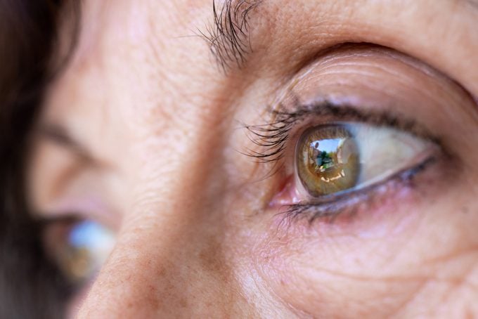 Adult woman green eyes with wrinkles closeup