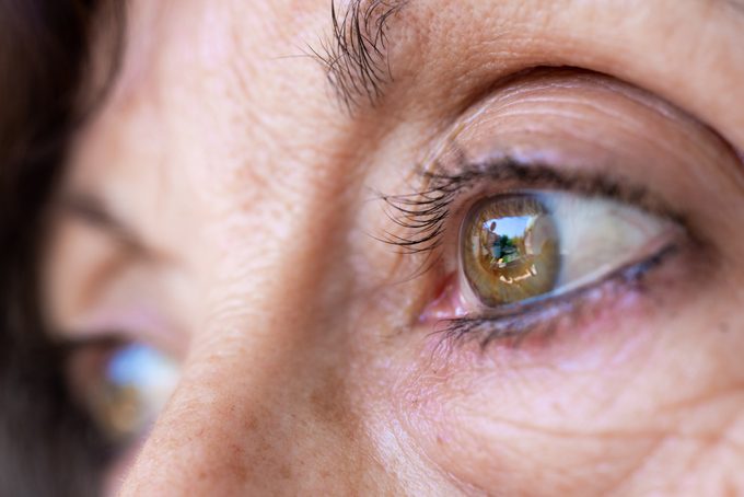 Volwassen vrouw groene ogen met rimpels close-up