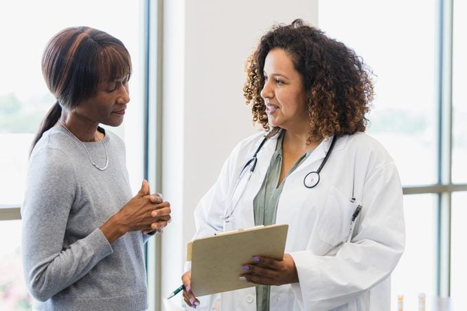 Female doctor and senior patient discuss medical records