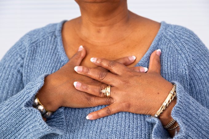 Senior African descent woman clutches chest in pain