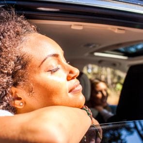 Black woman leaning out car window