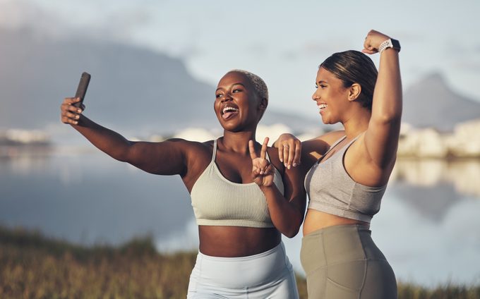 Zwei Frauen machen beim gemeinsamen Laufen ein Selfie