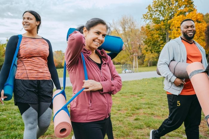 Tres personas saliendo con colchonetas de yoga para fortalecer los huesos