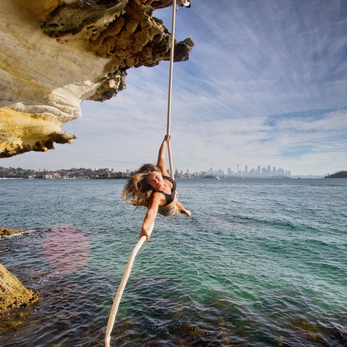 woman doing Aerials with rope above water