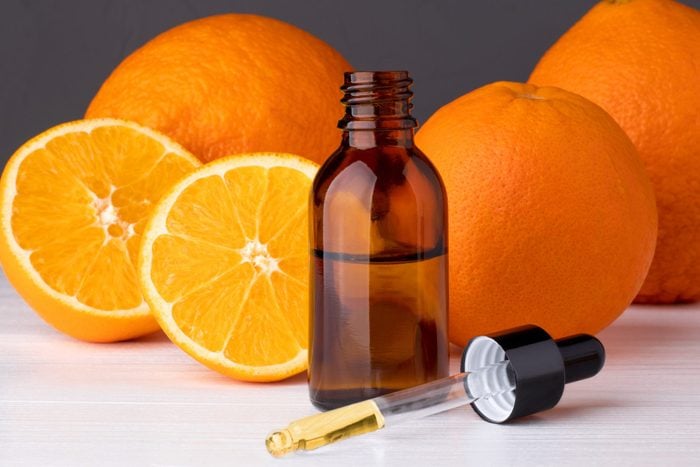 Bottle with essential oils, dropper with oil. Fresh oranges.