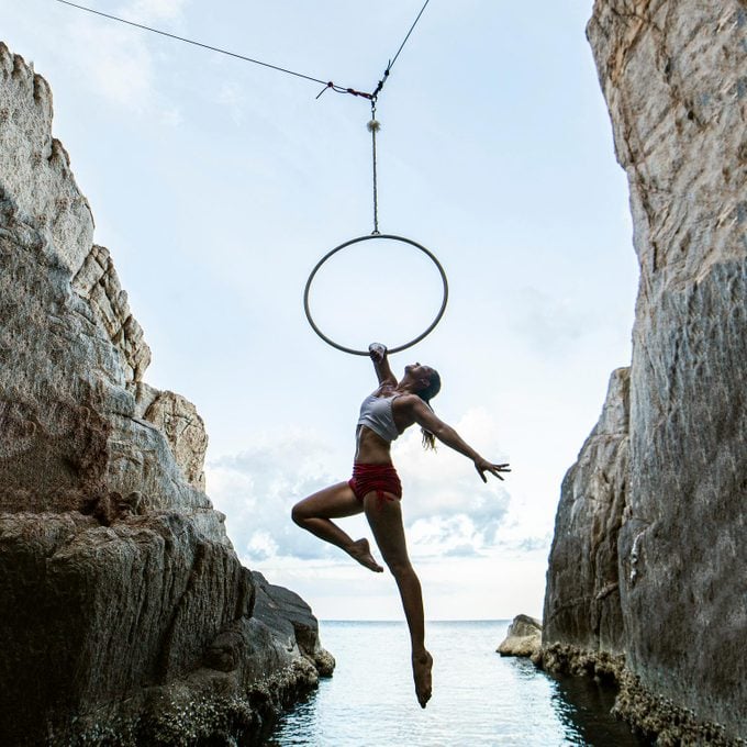 woman doing Aerials with hoop above water