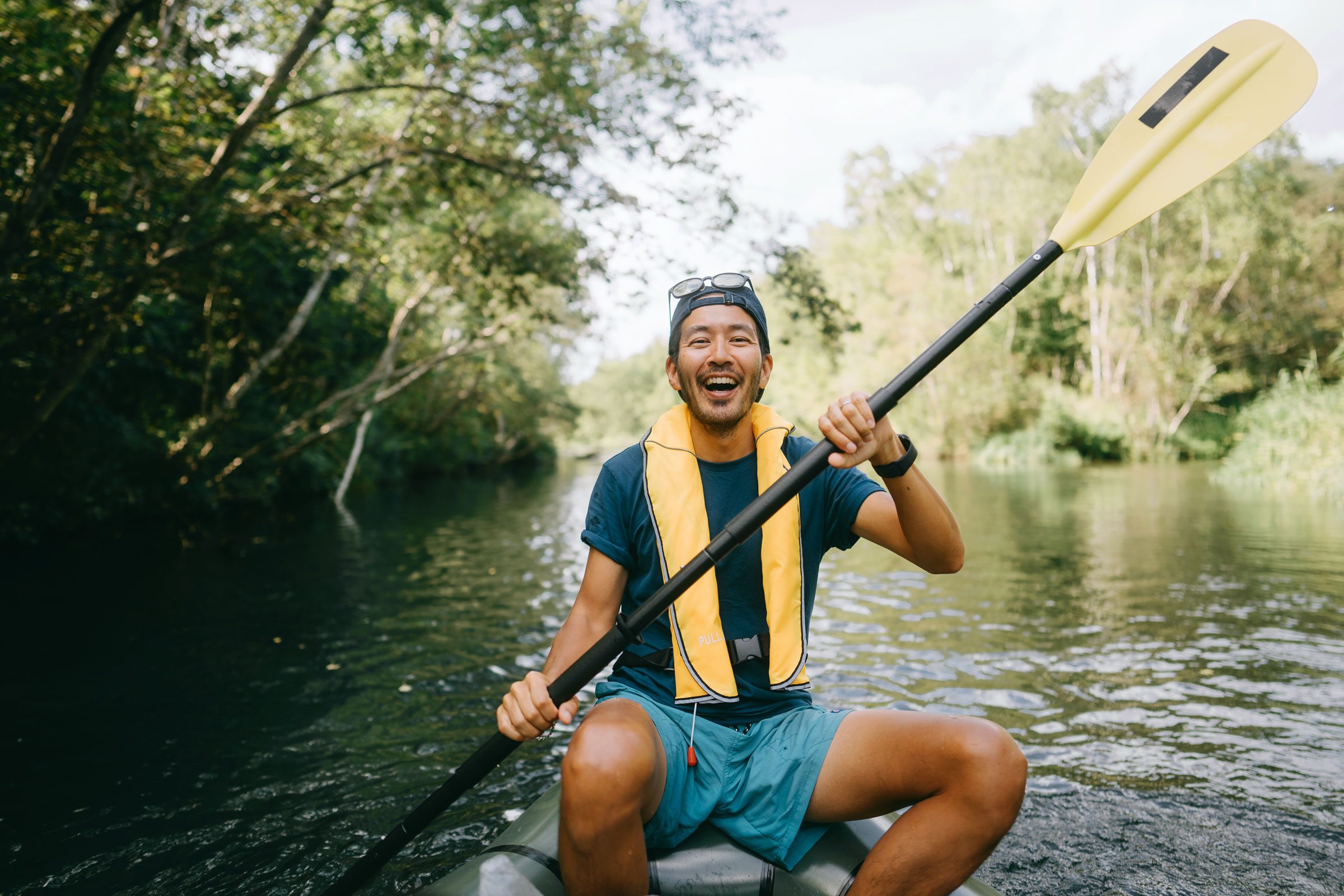 happy man kayaking down a river