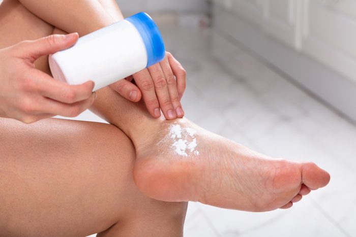 Woman Applying Powder On Her Feet